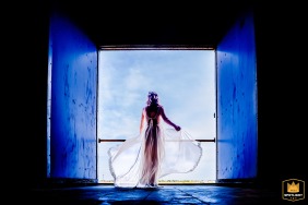 A beautiful bride gazes down at her wedding guests from a scenic balcony at the Honig Fabriek in Nijmegen, captured in this wedding day photograph.